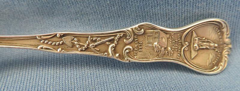 Souvenir Mining Spoon Wilkes-Barre Reverse Handle.JPG - SOUVENIR MINING SPOON WILKES-BARRE PA - Sterling silver souvenir demitassespoon, 4 in. long, bowl engraved with colliery buildings and marked WILKES-BARRE, handle marked with image of William Penn and Liberty Bell with Pennsylvania, reverse marked Sterling and maker’s mark of Mechanics Sterling Co. (Attleboro, MA 1896 - ?), reverse handle marked with pick and shovel along with state seal  [Wilkes-Barre is in the center of the Wyoming Valley anthracite coal region in northeastern Pennsylvania.  Founded in 1769, it was originally named Wyoming but renamed later in honor of two British members of parliament, John Wilkes and Col. Issac Barre, who defended the American colonies in parliamentary debates.  In 1818, Wilkes-Barre was incorporated as a borough, with a city charter following in 1871.  Coal mining was the most important element of the city’s economy.   Hundreds of thousands of immigrants flocked to the city; they were seeking jobs in the numerous mines and collieries that sprang up.  Wilkes-Barre’s population exploded as the city became a center of supply to support these mines.  In 1914 employment at the anthracite mines reached a maximum of 180,000 workers.  Anthracite production peaked in 1917 at over 100 million tons with 776 mines in operation.  The anthracite industry went into steady decline after World War I.  The primary reason was competition from abundant supplies of lower cost oil and gas.  A large drop in anthracite production occurred during the Depression with only a small bounce-back during World War II.  The earlier downward trend continued after the War.  In 1959, The Knox Mine near Wilkes-Barre broke through the bottom of the Susquehanna River, flooding the underground mines and ending deep coal  production in the area.]